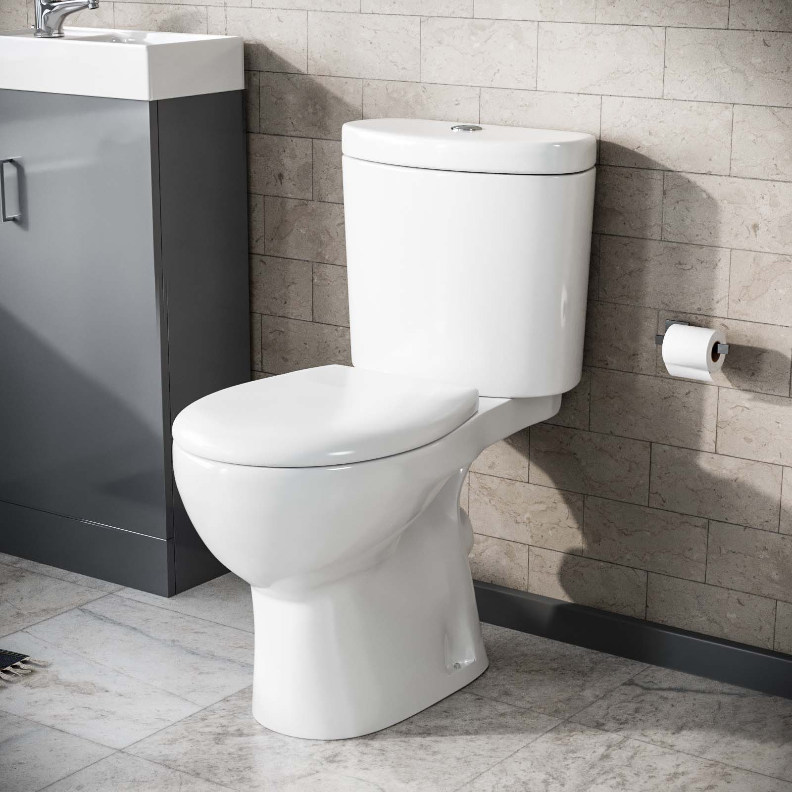 White rimless close coupled toilet with exposed cistern and chrome flush plate against grey wall tiles — Bathroom Republic UK