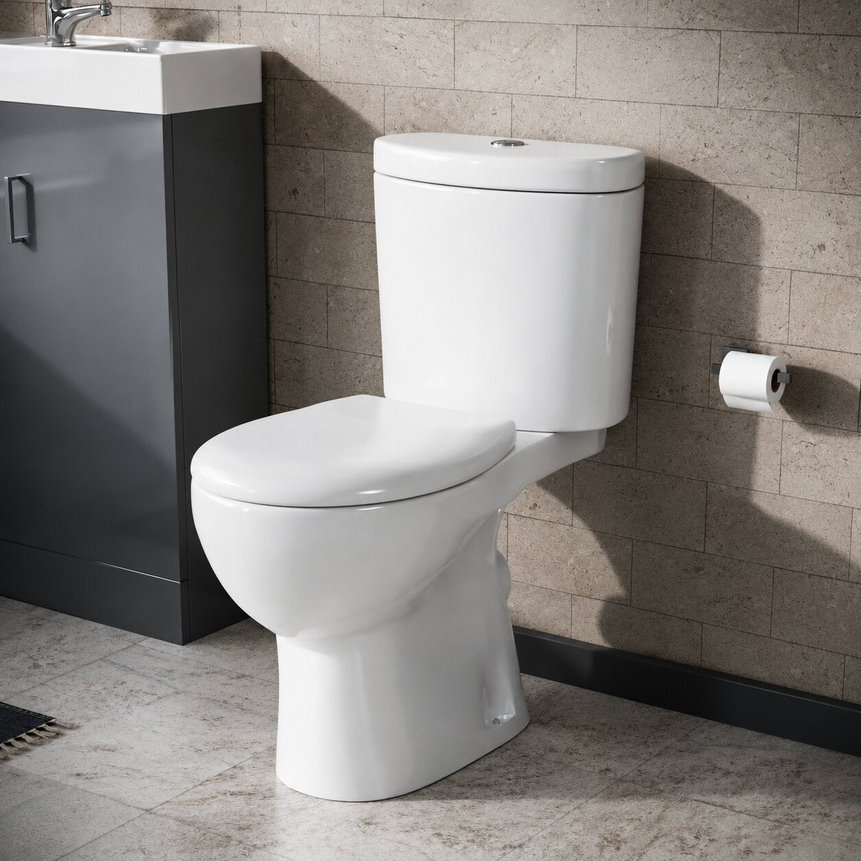 White rimless close coupled toilet with exposed cistern and chrome flush plate against grey wall tiles — Bathroom Republic UK