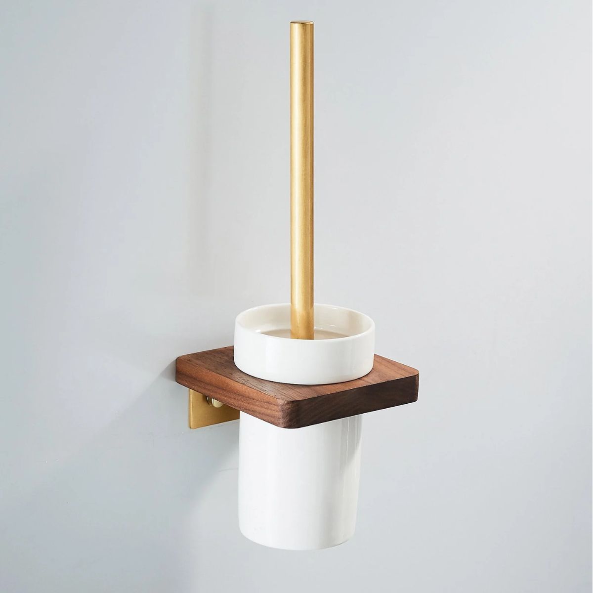 White toilet brush and holder with brushed brass stem and wooden shelf on a grey bathroom wall — Bathroom Republic UK