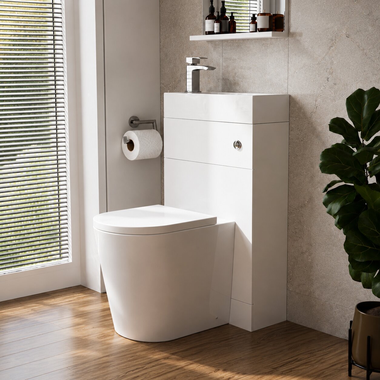 Compact white toilet and vanity unit combination with integrated basin, chrome tap, stone-effect wall tiles and wood flooring in a modern small bathroom designed for UK homes.
