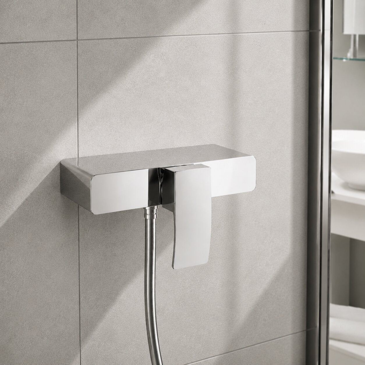 Modern chrome exposed square shower mixer valve with single lever control, polished chrome finish and stone-effect wall tiles in a contemporary UK bathroom.