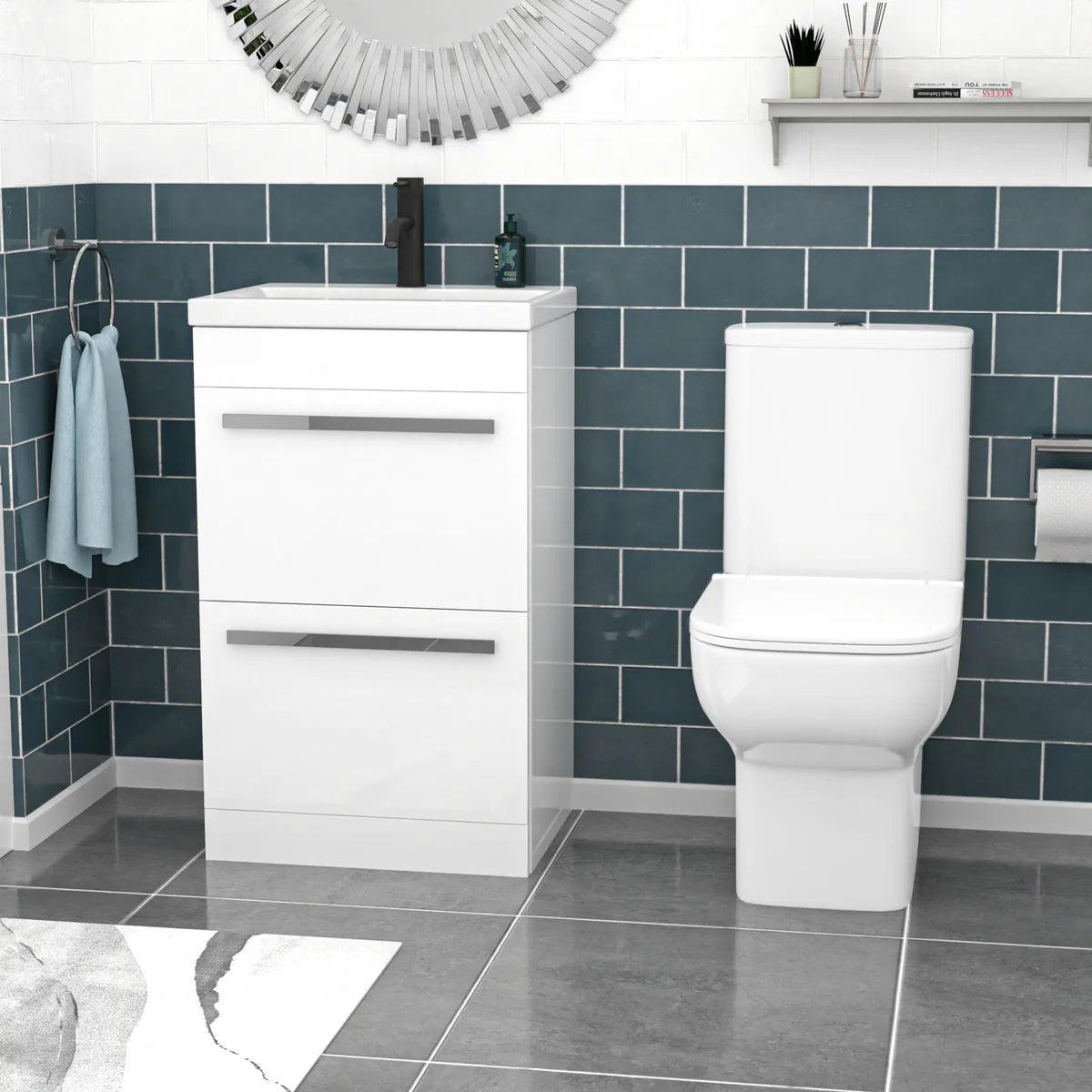 Bathroom setup with a white vanity unit and toilet against a blue tiled wall.