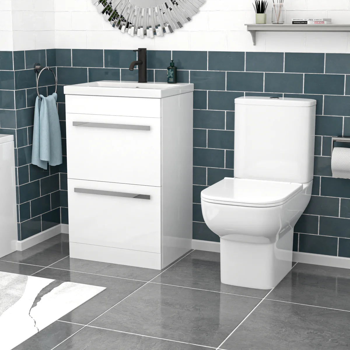 Bathroom with white toilet and vanity unit against a blue tiled wall.