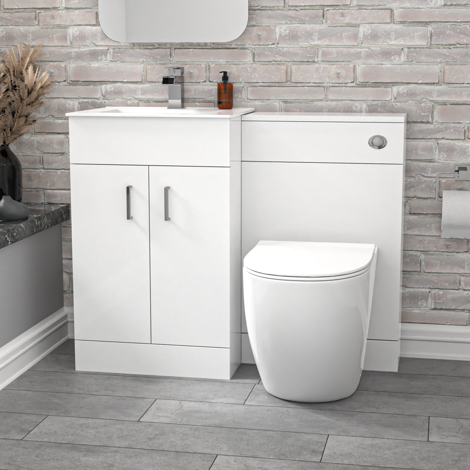 Bathroom setup with white vanity unit and toilet against a brick-patterned wall.