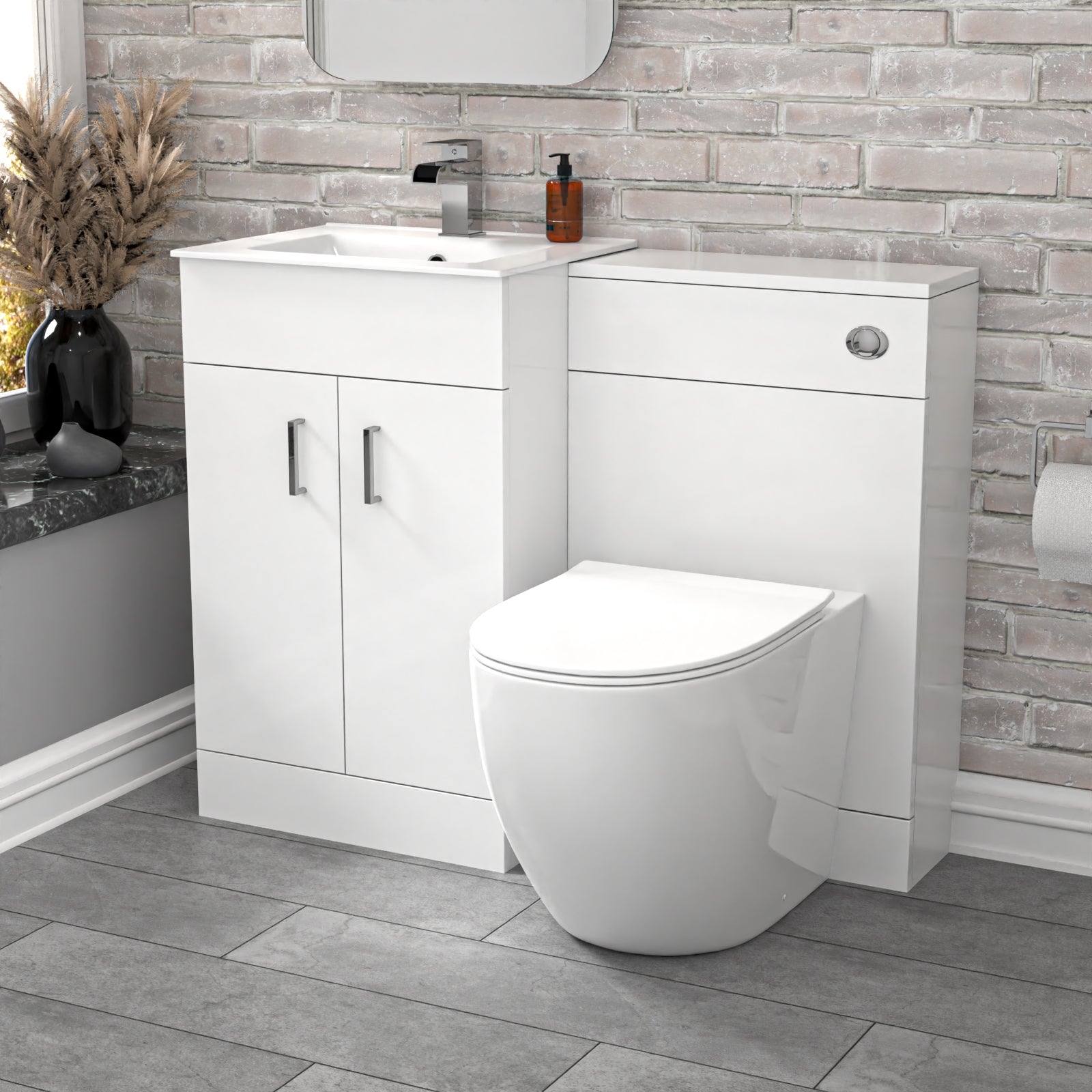 Bathroom setup with white vanity unit and toilet against a brick-patterned wall.