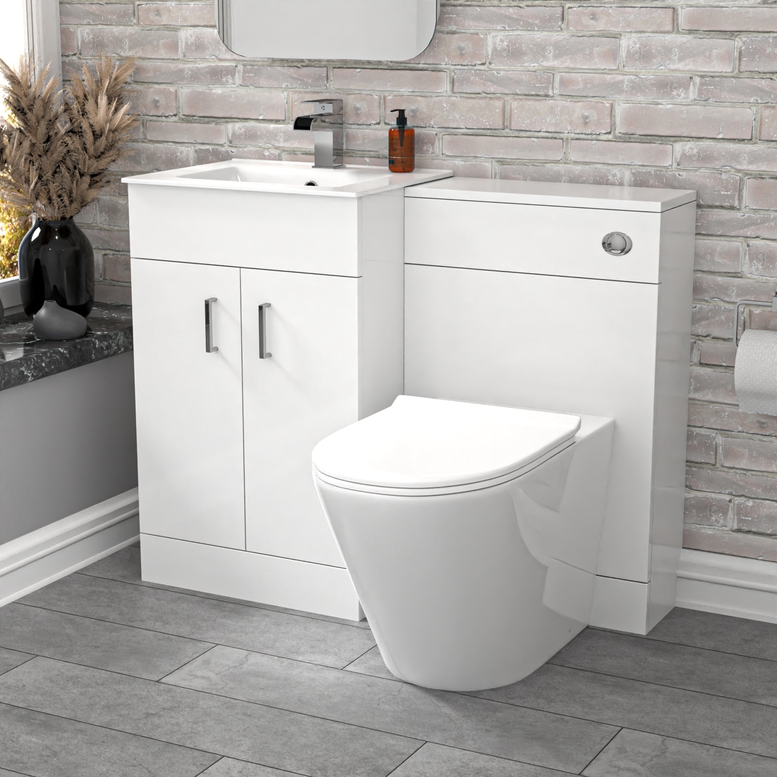 Bathroom setup with white vanity unit and toilet against a brick-patterned wall.