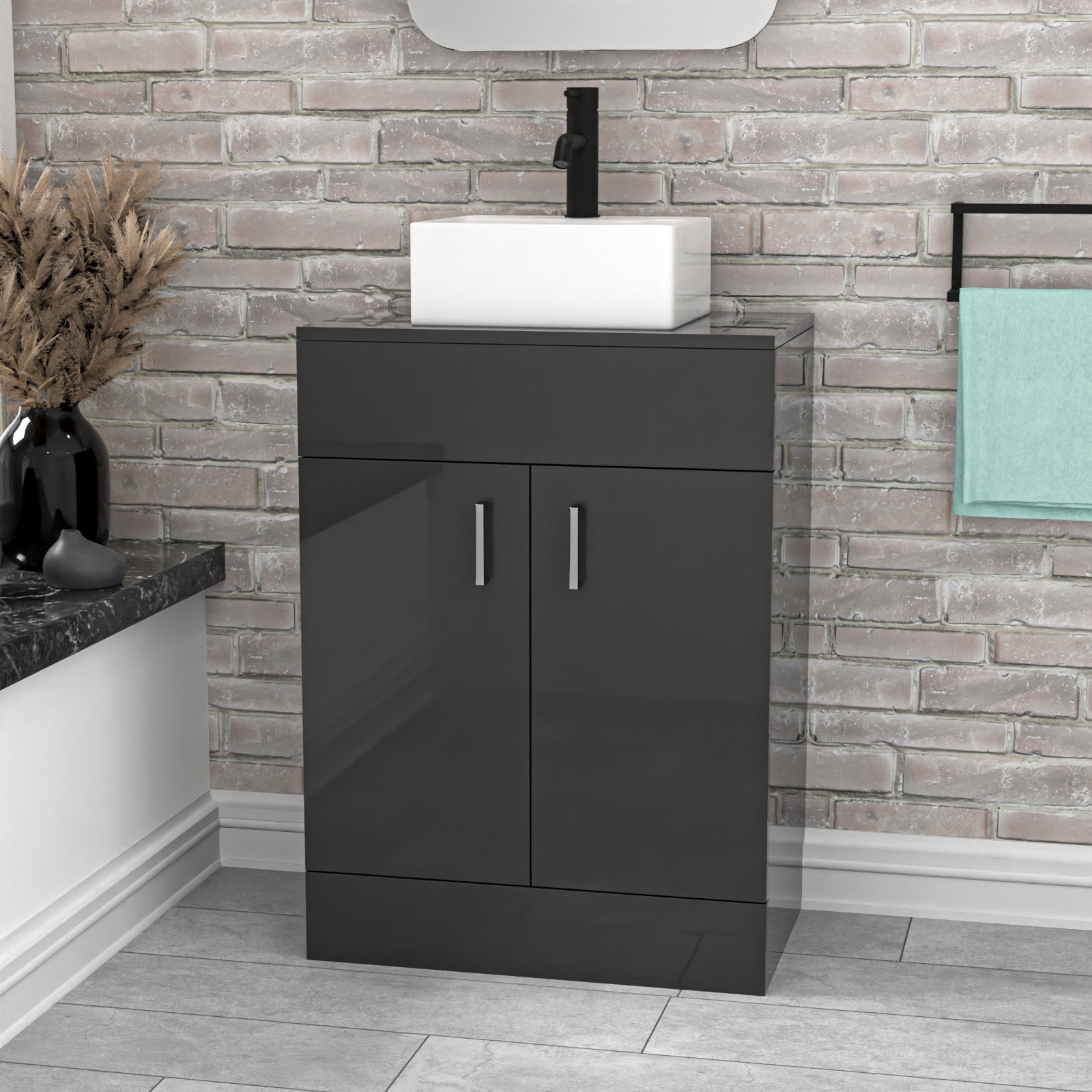 Bathroom vanity with black cabinet and white basin against a brick wall.
