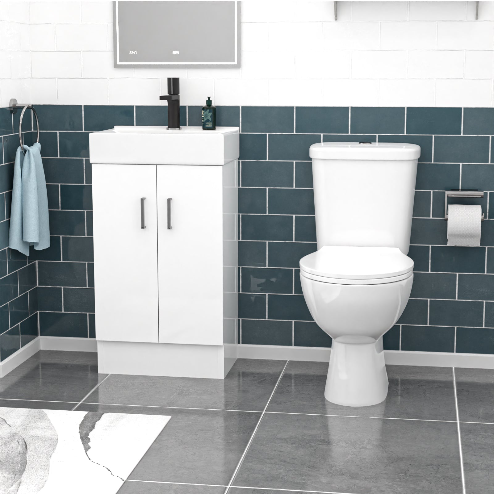 Bathroom setup with a white toilet and vanity unit against a blue tiled wall.