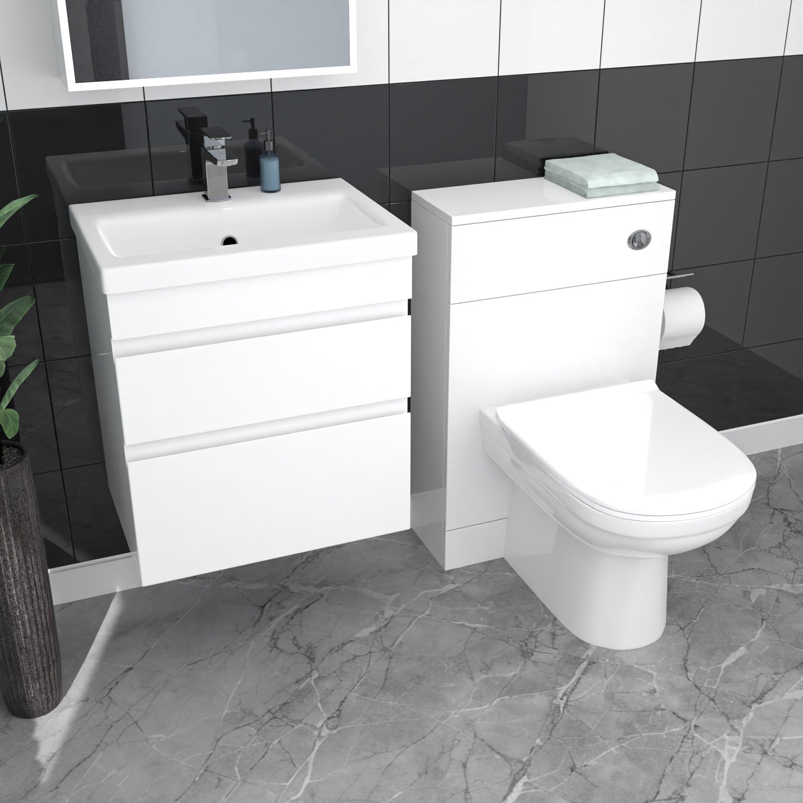Bathroom setup with white vanity unit and toilet against a black tiled wall.