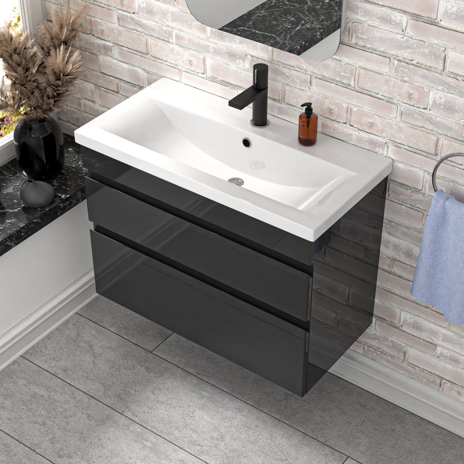 Bathroom vanity with white sink and black drawers against a brick wall.