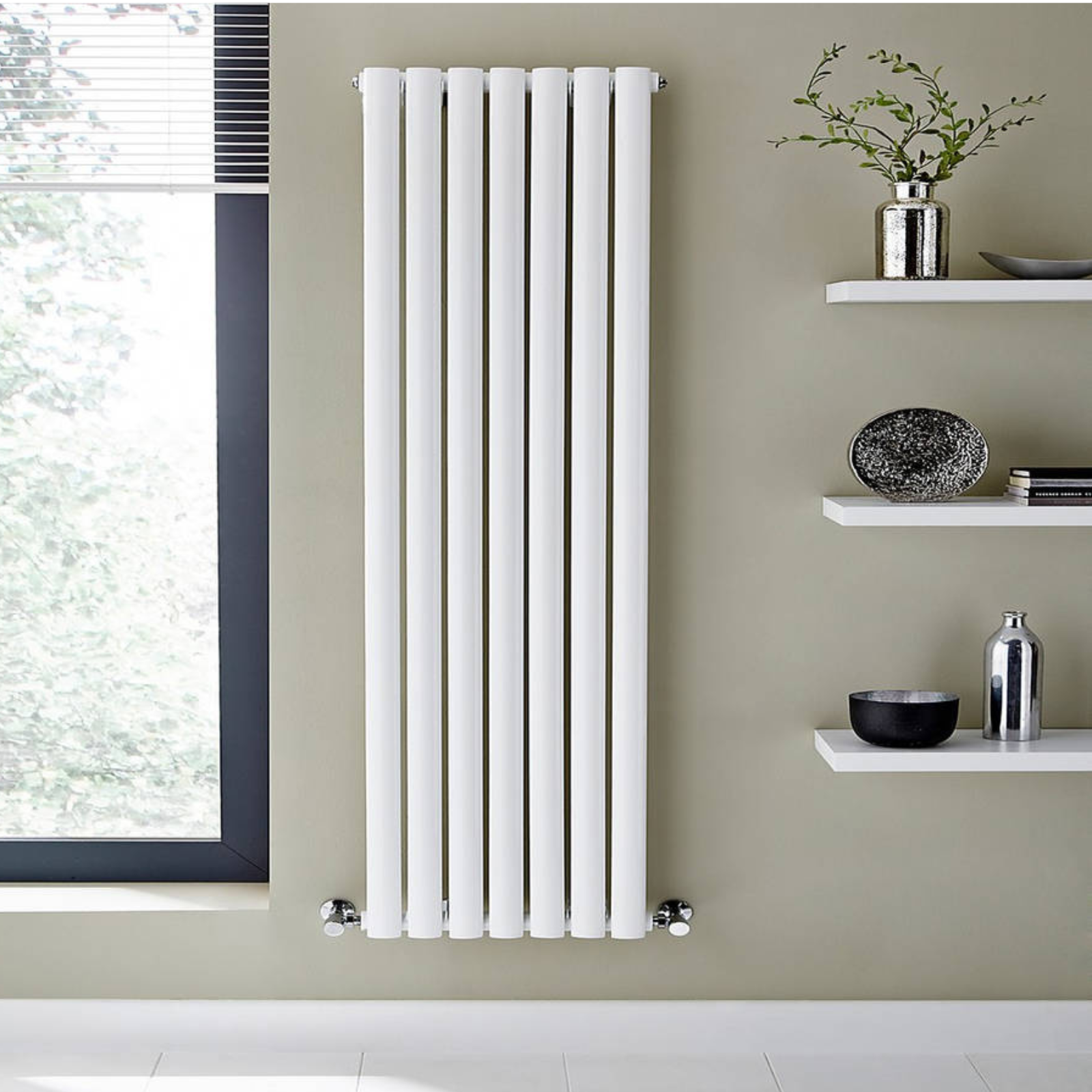 White vertical radiator on a wall with decorative items on shelves.