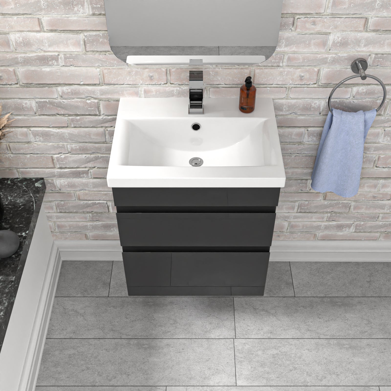 Bathroom vanity with white sink and dark gray cabinet against a brick wall.