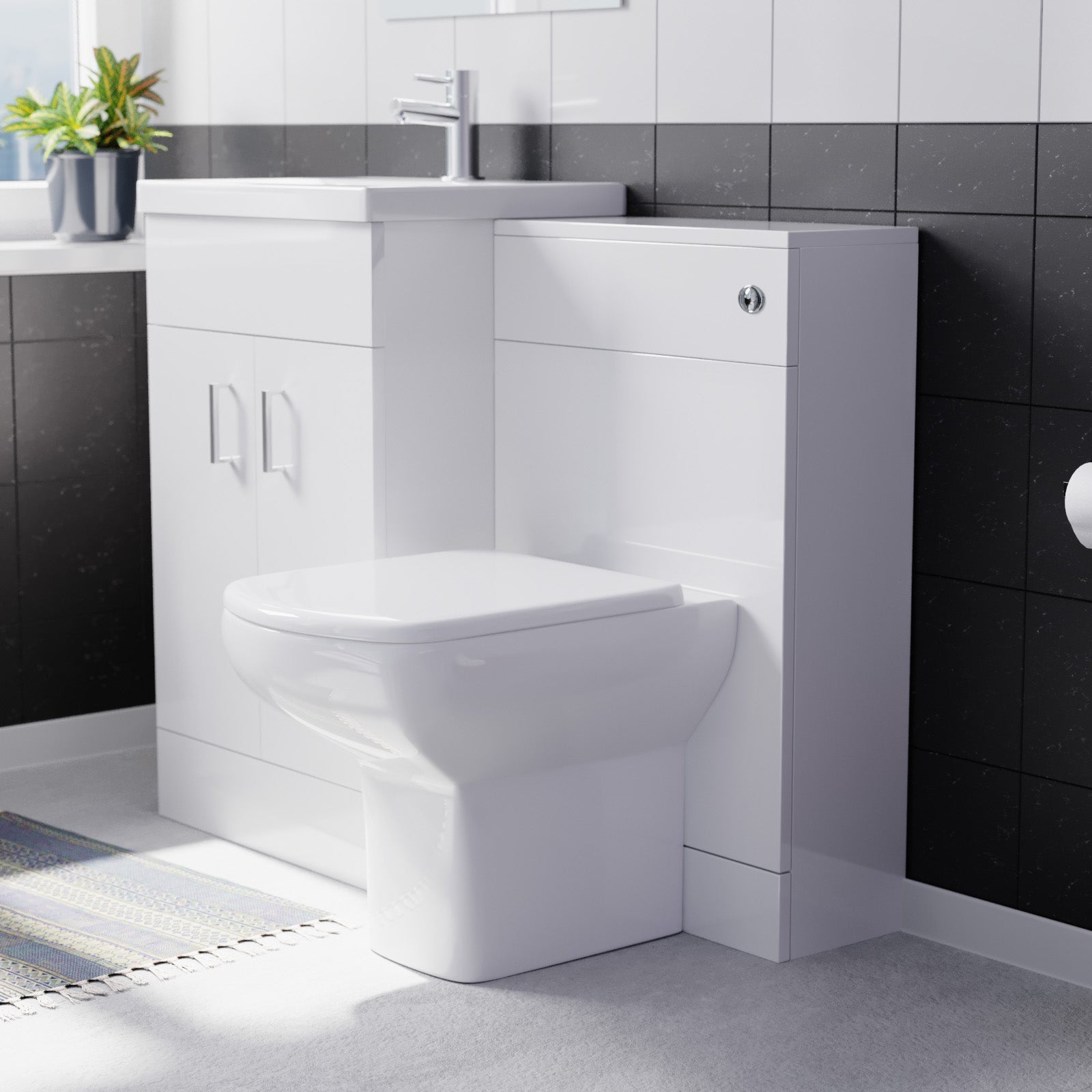 Bathroom setup with a white toilet and vanity unit against a black tiled wall.