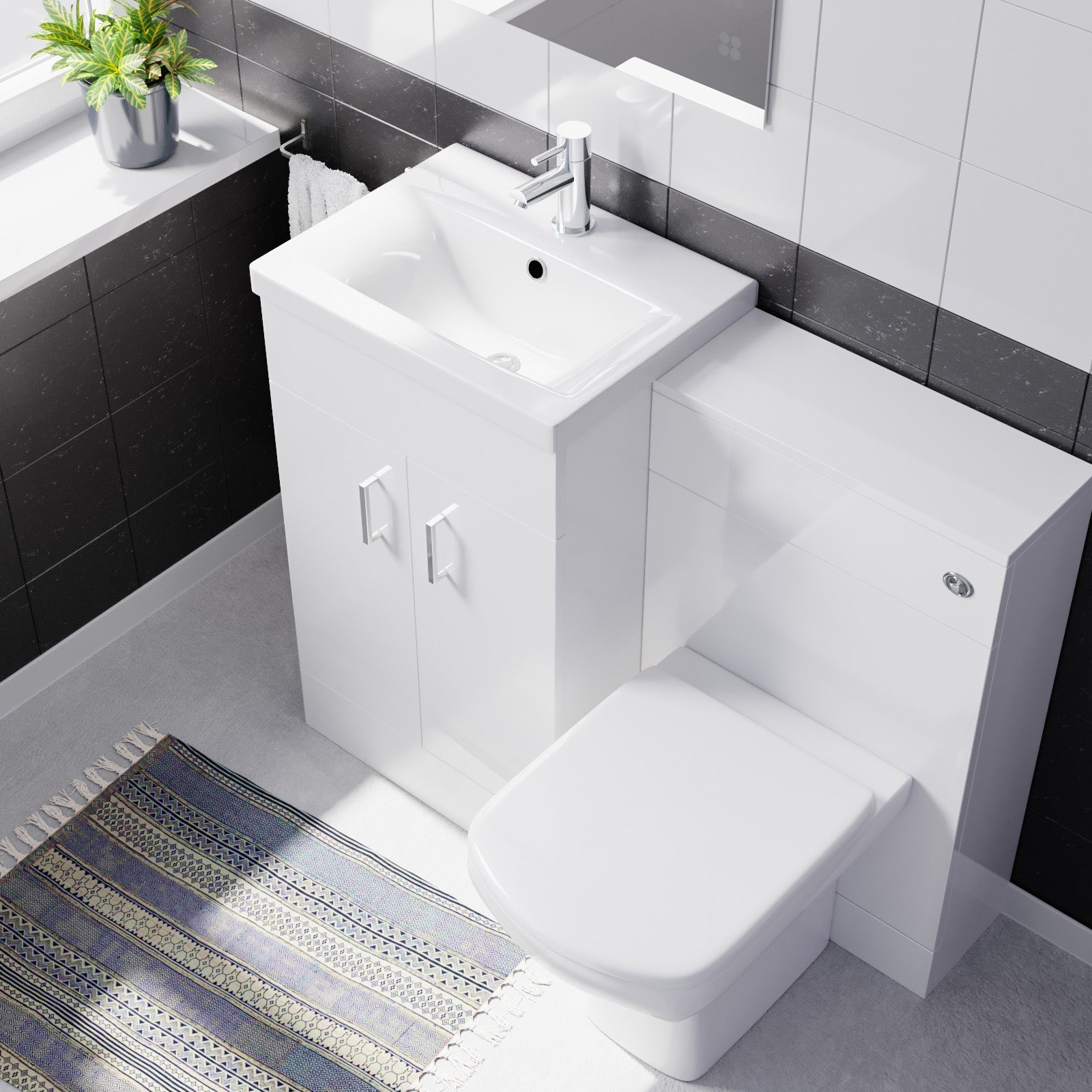 Modern bathroom with white toilet and sink vanity against a black tiled wall.