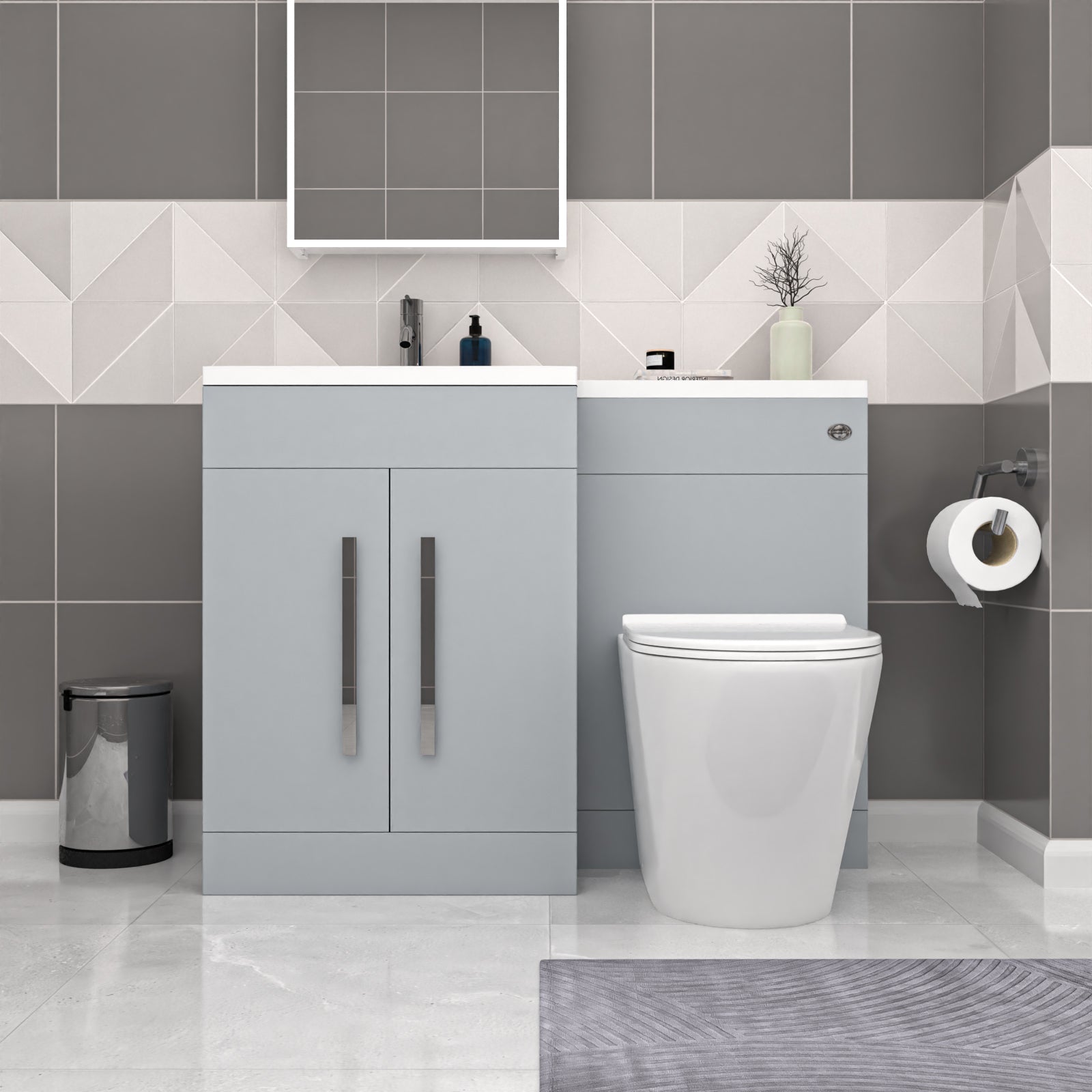 Bathroom setup with gray vanity unit, white toilet, and geometric tile pattern.