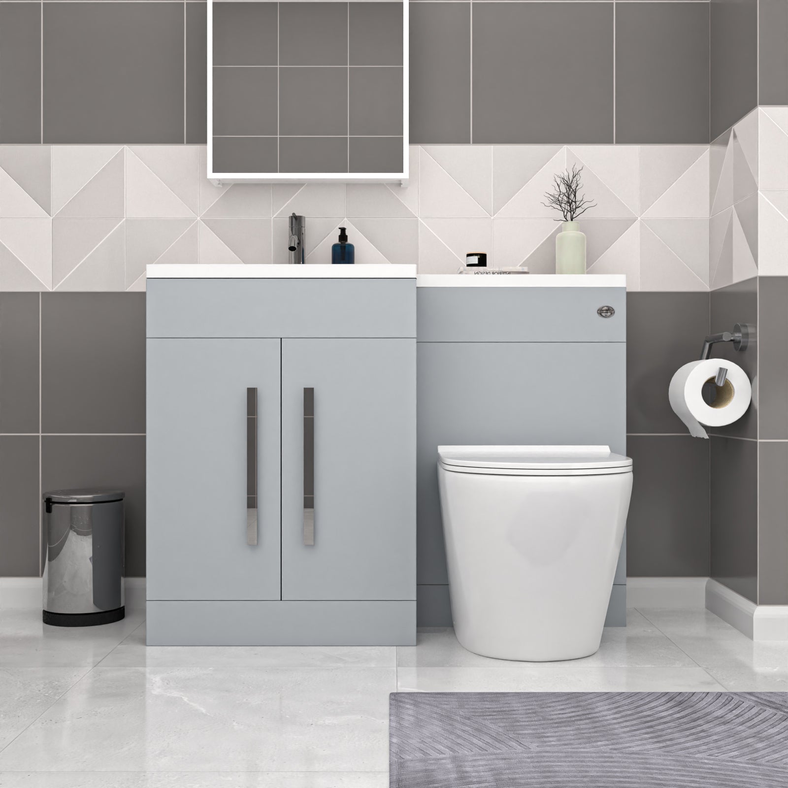 Bathroom setup with gray vanity unit, white toilet, and geometric tile pattern.