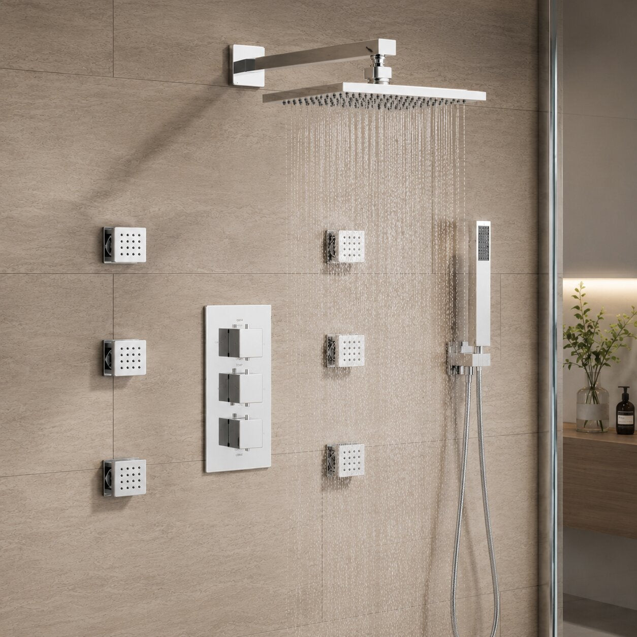 Luxury chrome concealed thermostatic shower system featuring a square rainfall shower head, body jets, handheld shower, concealed triple control valve and stone-effect wall tiles in a contemporary UK bathroom.