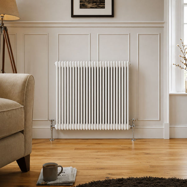 White traditional column radiator beside armchair in a room with wooden flooring — Bathroom Republic UK