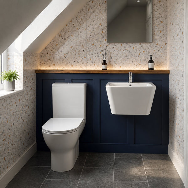 Modern under-stairs cloakroom featuring a white close coupled toilet, wall-hung basin, navy blue vanity panelling, terrazzo wall tiles, slate floor tiles and warm LED lighting in a contemporary UK home.