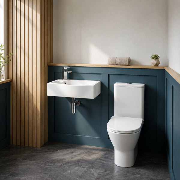 Modern cloakroom bathroom featuring a wall-hung ceramic basin, close coupled toilet, teal wall panelling, timber slat feature wall, chrome mixer tap and dark stone-effect floor tiles in a contemporary UK home.