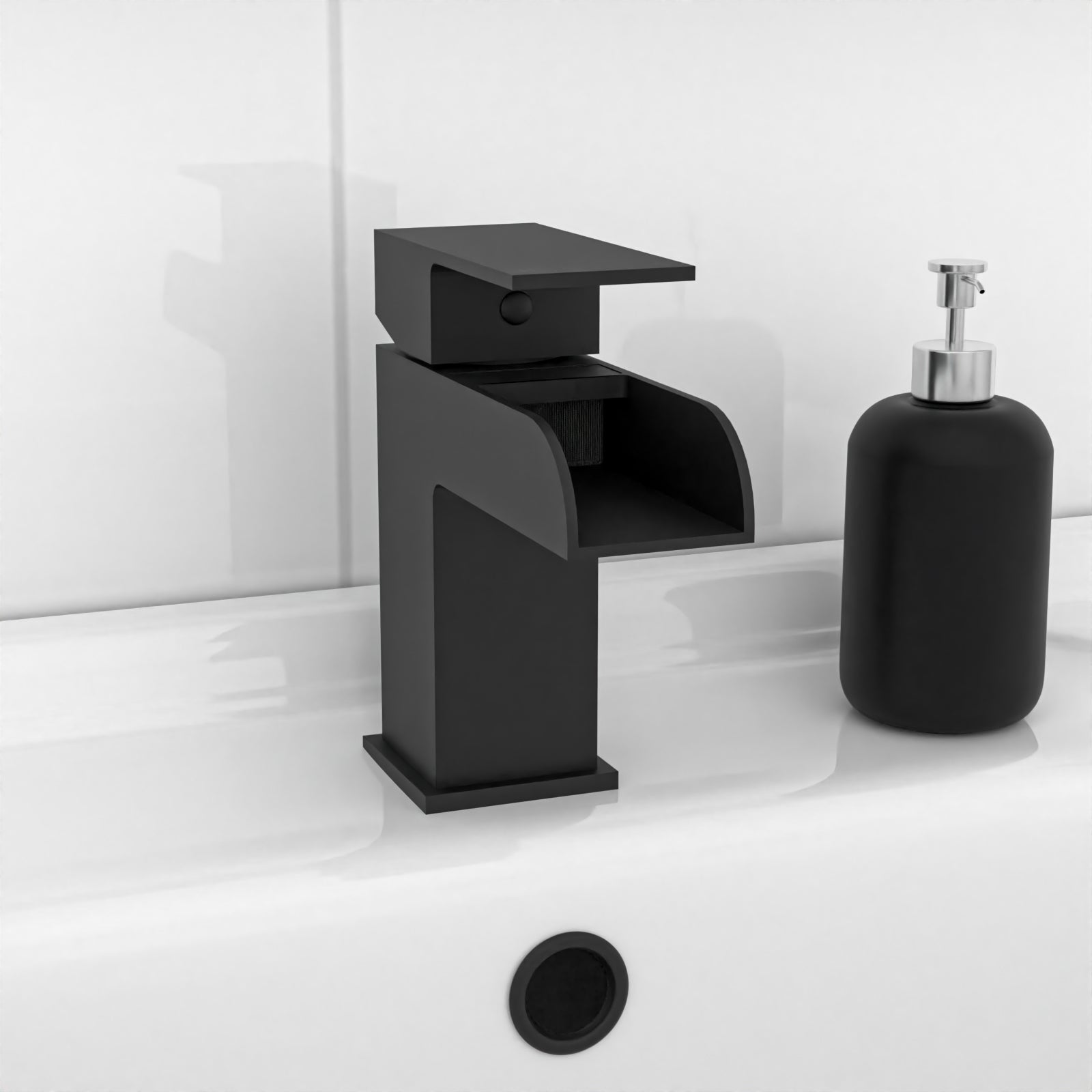 Black faucet and soap dispenser on a white bathroom counter