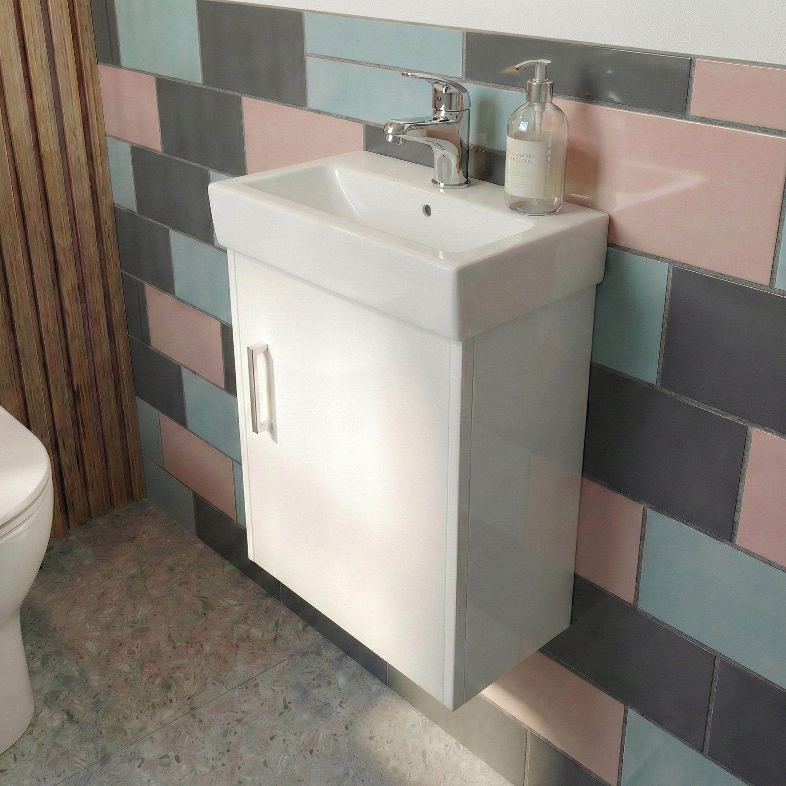 Bathroom with a white sink and cabinet against a colorful tiled wall.