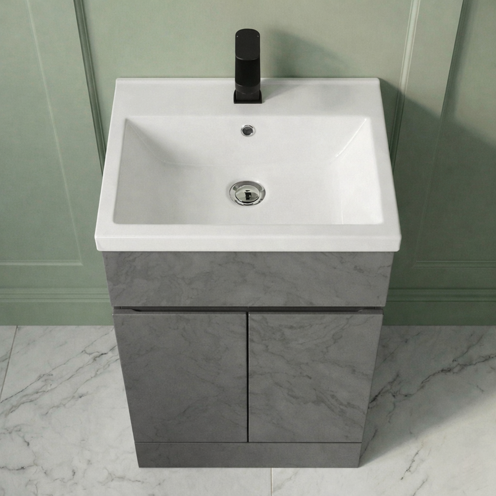 Bathroom vanity with white sink and gray cabinet against a green wall.