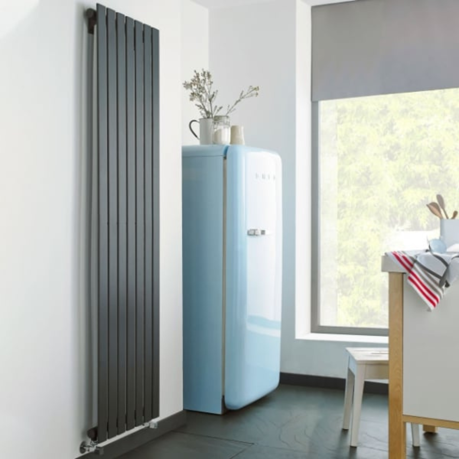 Modern radiator next to a vintage-style blue refrigerator in a room with a window.