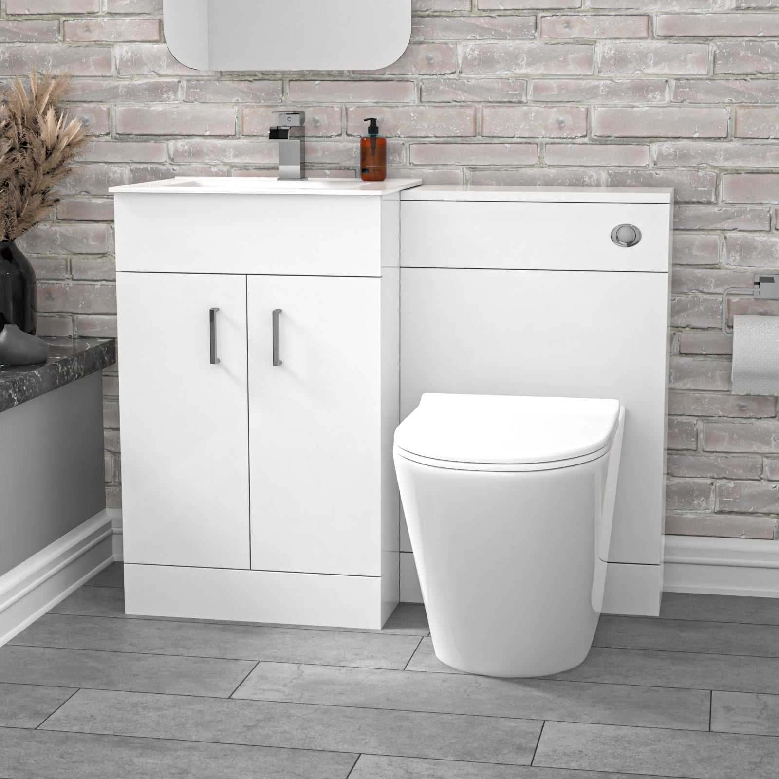 Bathroom setup with white vanity unit and toilet against a brick-patterned wall.