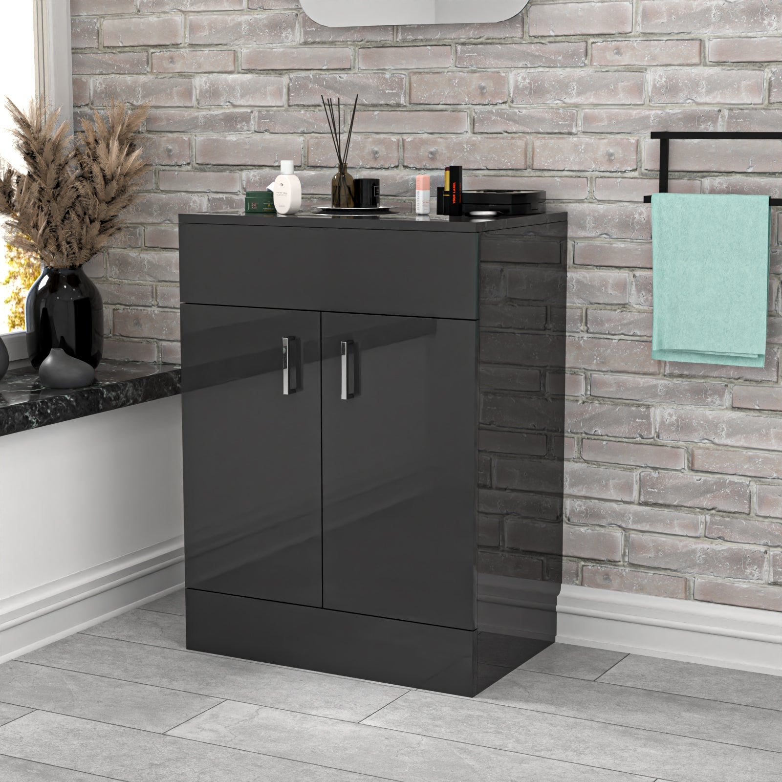 Black vanity unit with sink in a bathroom setting with stone wall and towel.
