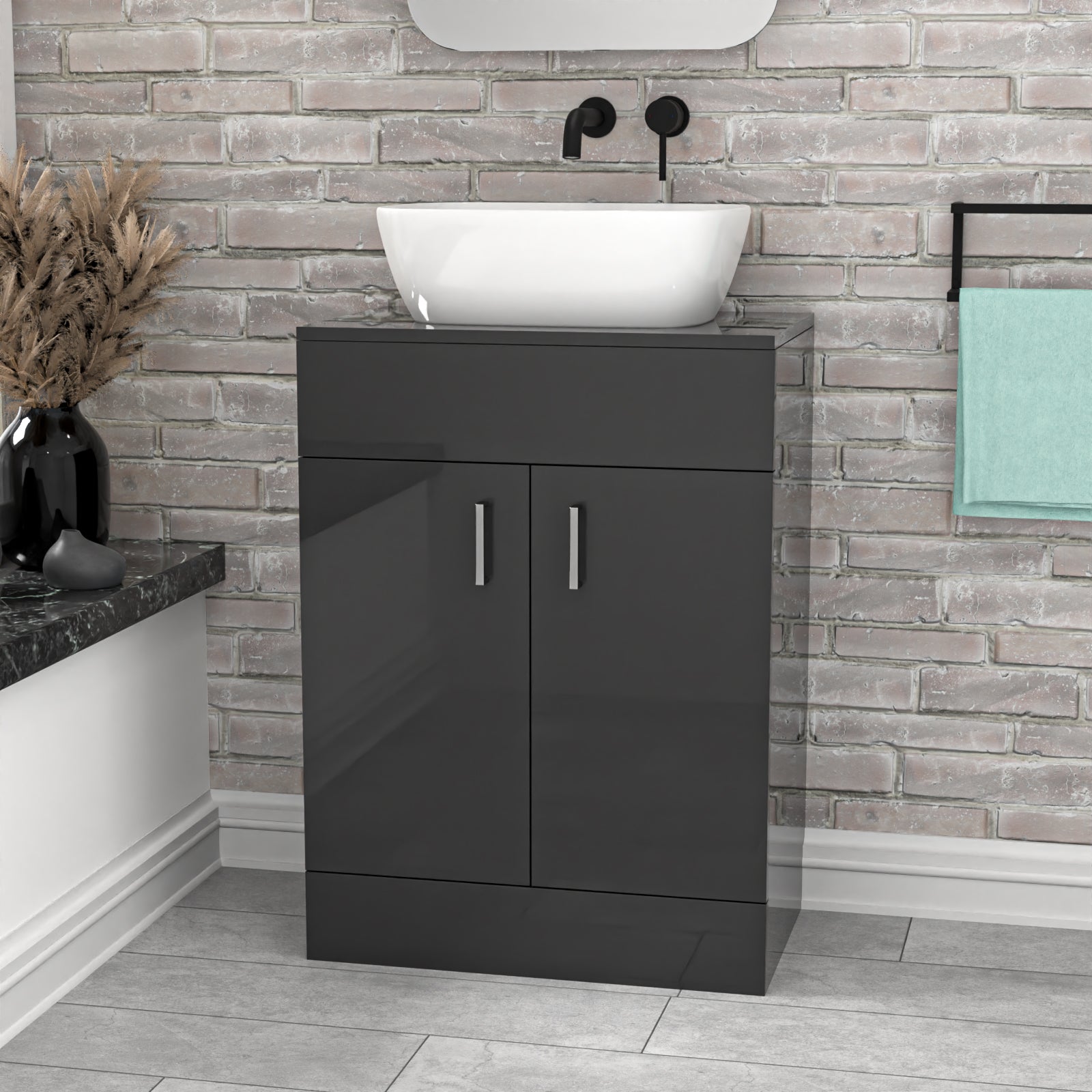 Bathroom setup with a black vanity unit, white basin, and brick wall.