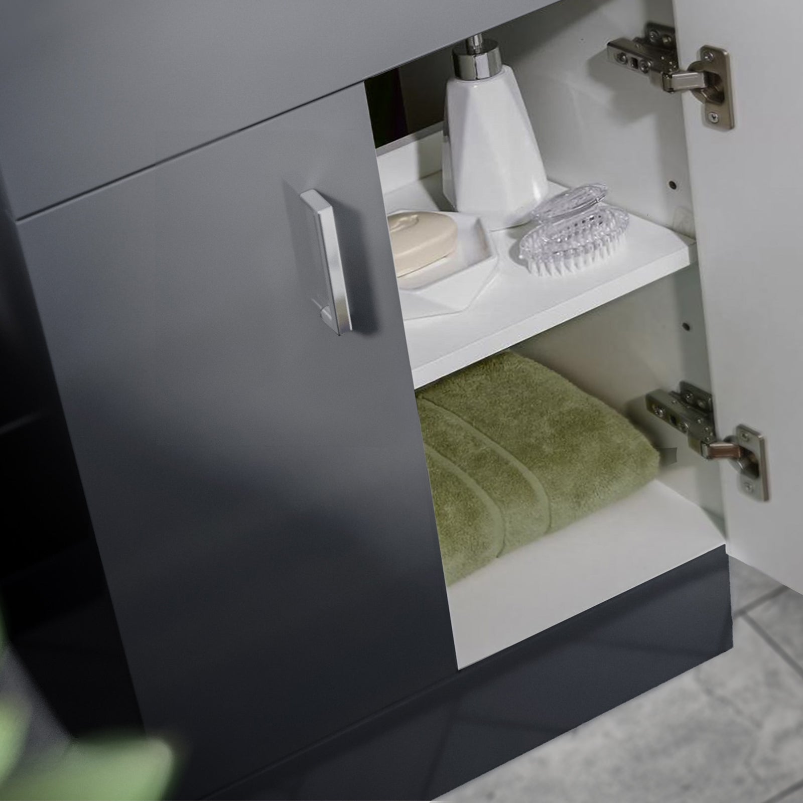 Bathroom cabinet with open door revealing a green towel, soap, and other items.