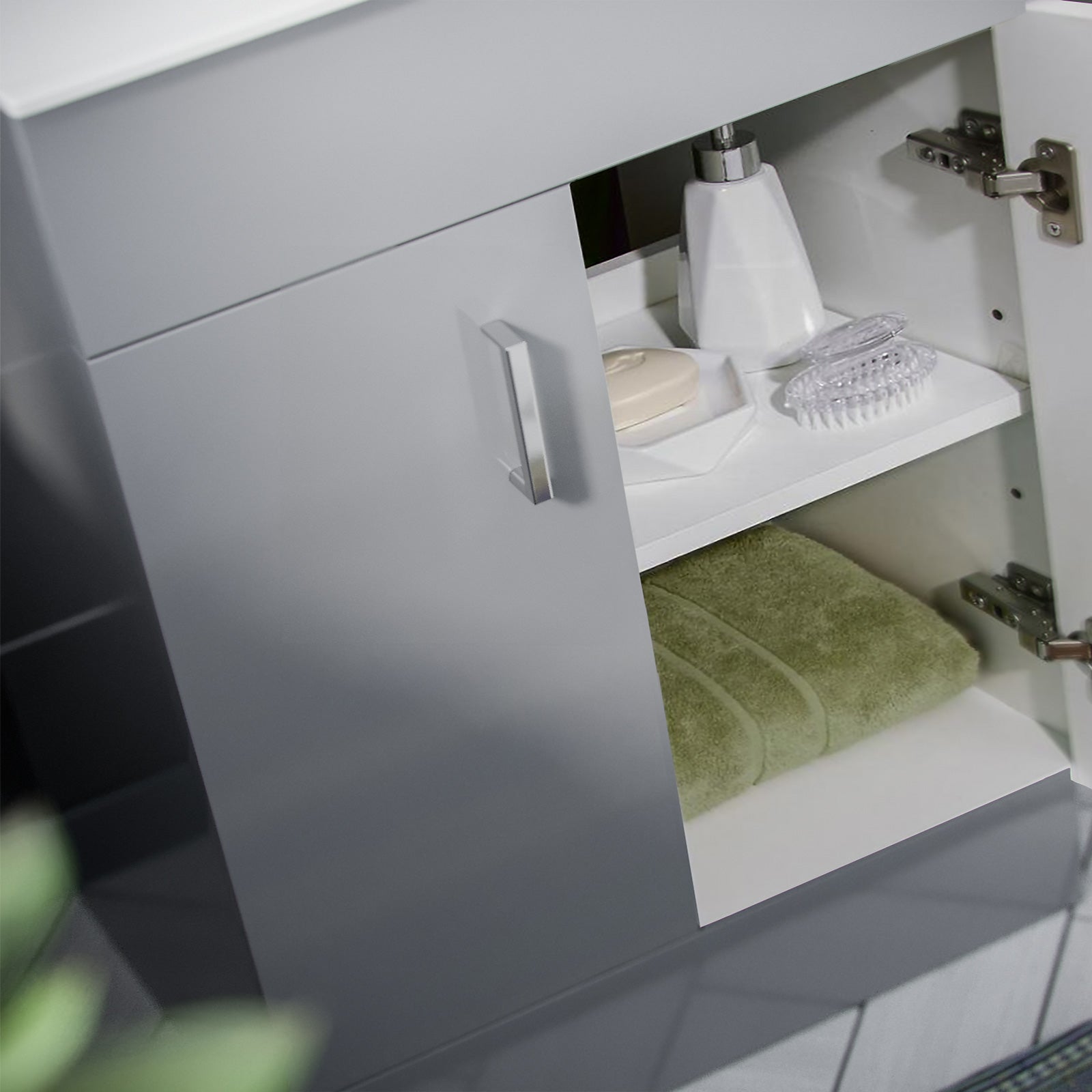 Gray bathroom cabinet with open door revealing toiletries and a green towel.