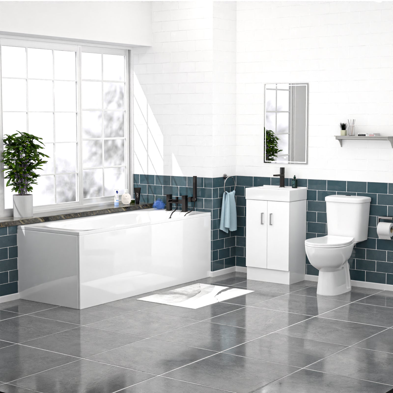 Modern bathroom with white bathtub, toilet, and vanity against a blue tiled wall.