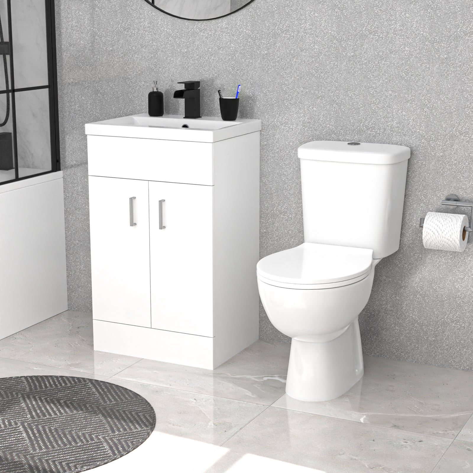 Bathroom setup with a white vanity unit and toilet against a gray tiled wall.
