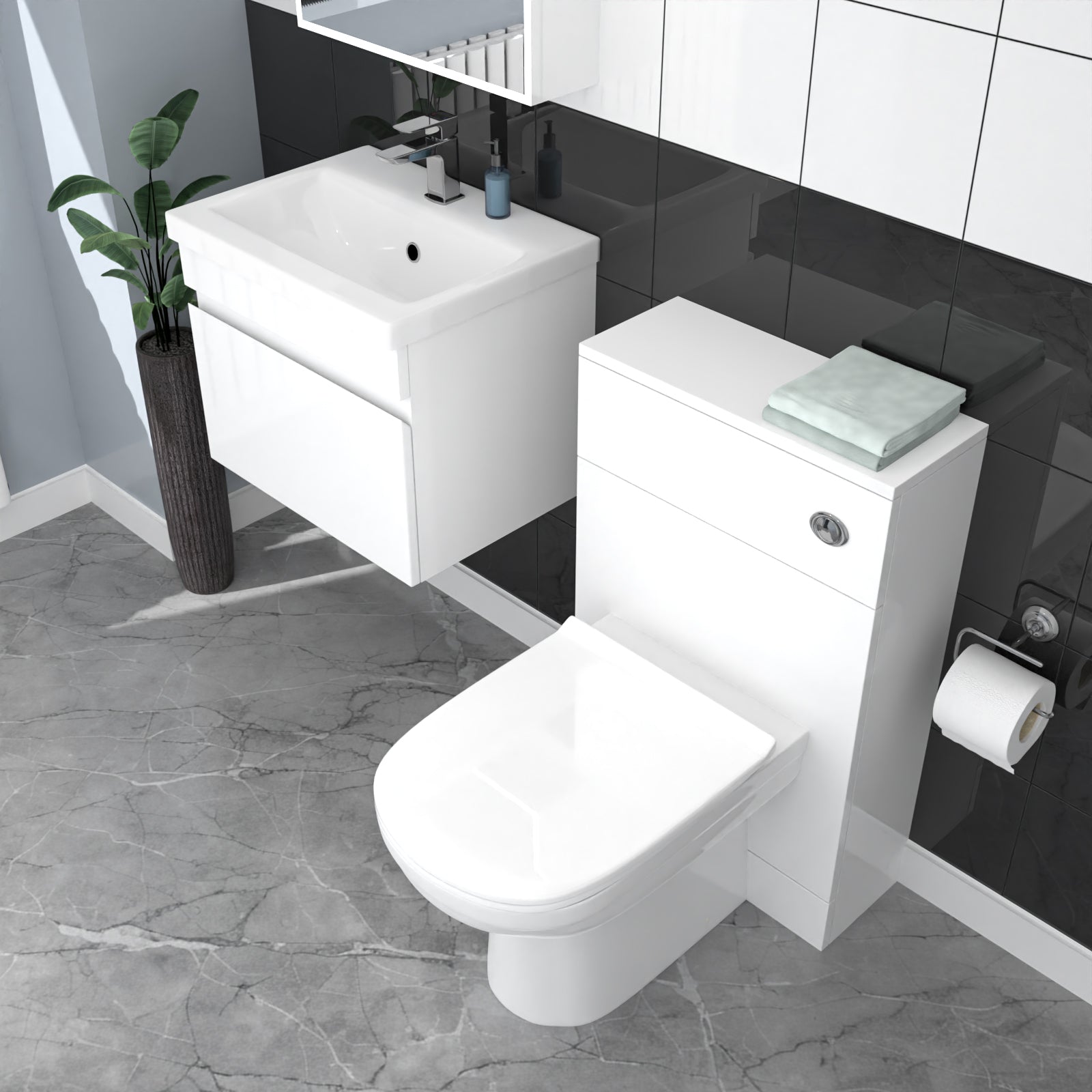 Bathroom setup with white vanity unit, toilet, and sink against a black tiled wall.