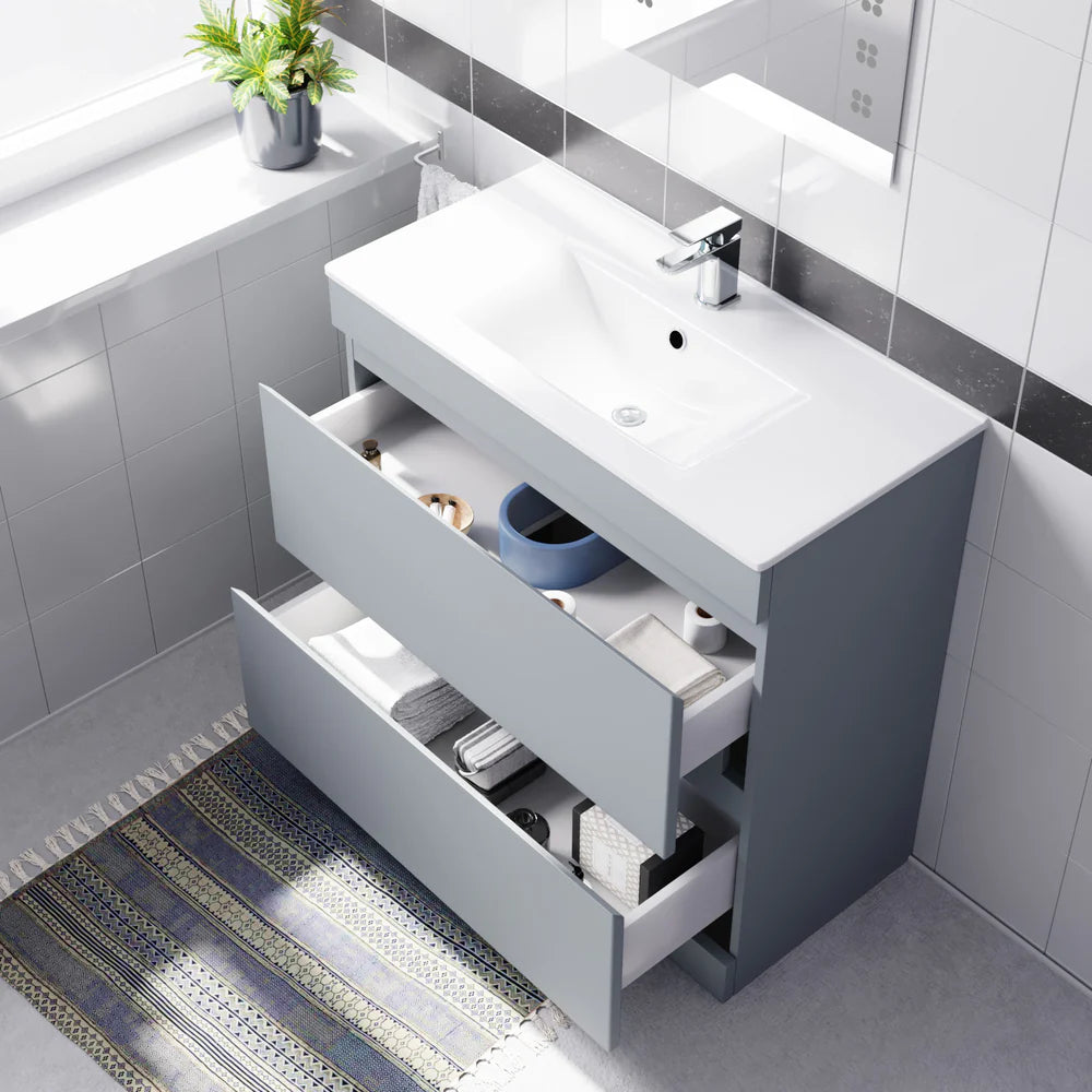 Bathroom vanity with open drawers and a sink, featuring a plant and rug on the floor.