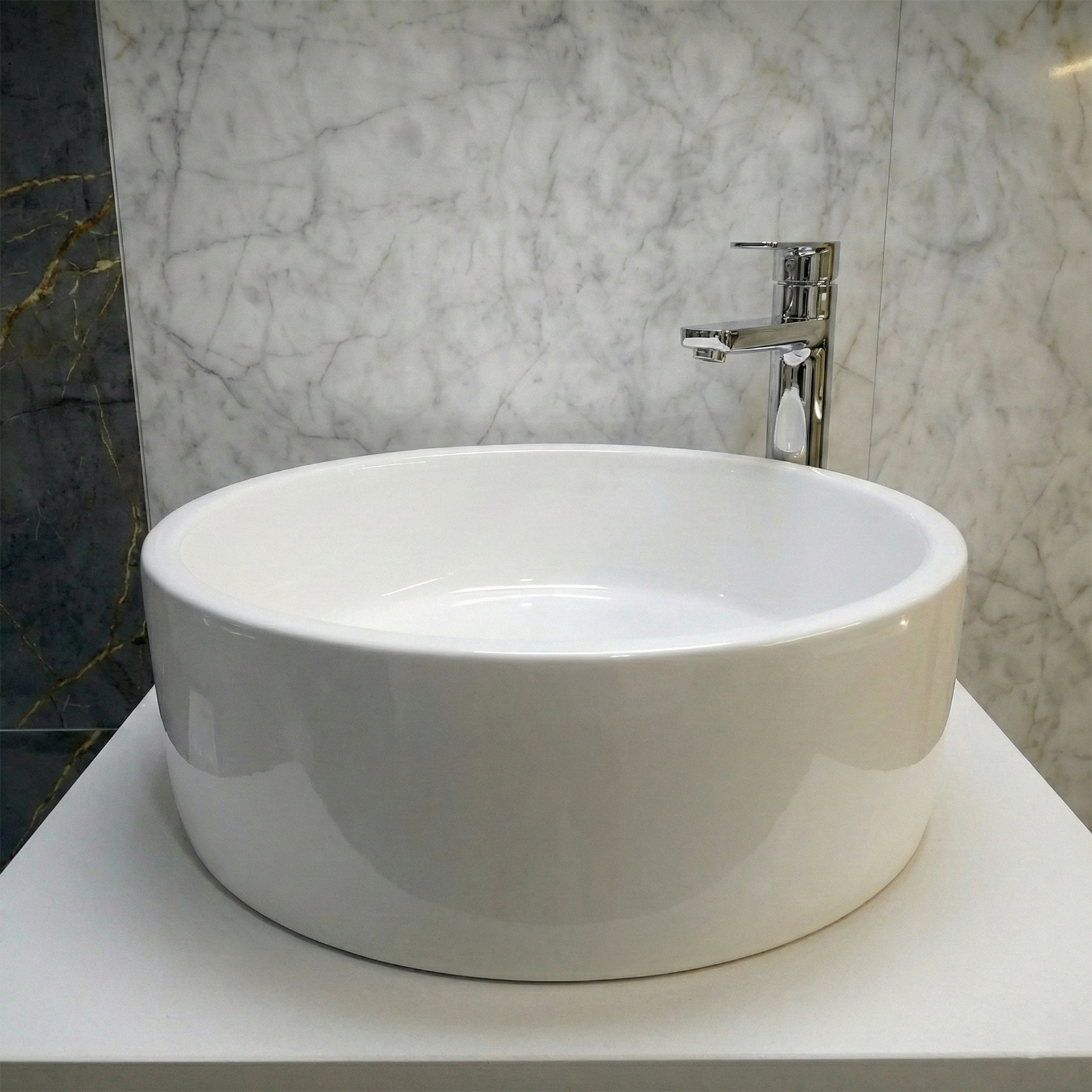 Cloakroom Round Countertop Basin with a metal tap/faucet/spout in a marble tiled bathroom