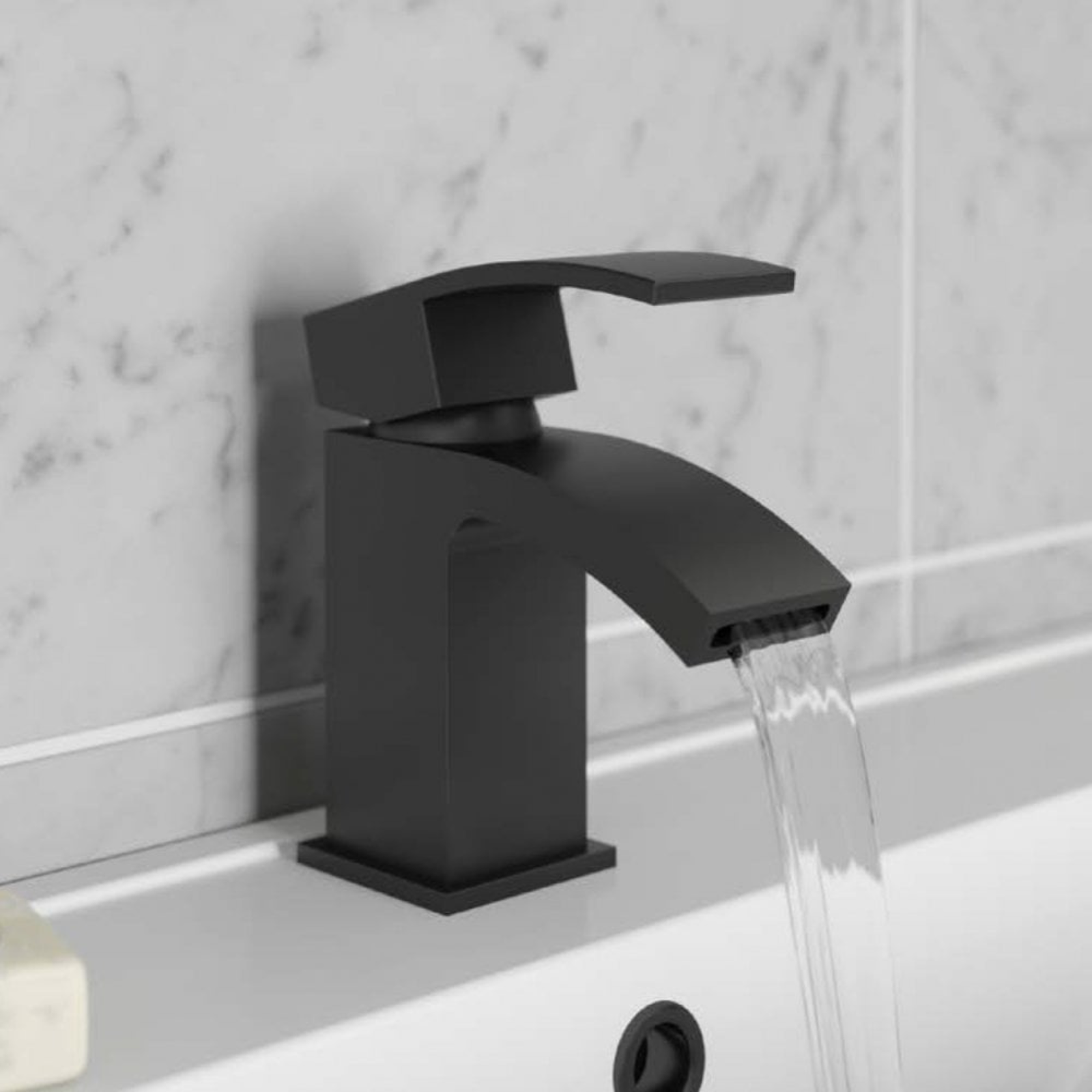 Black faucet with water flowing in a bathroom setting