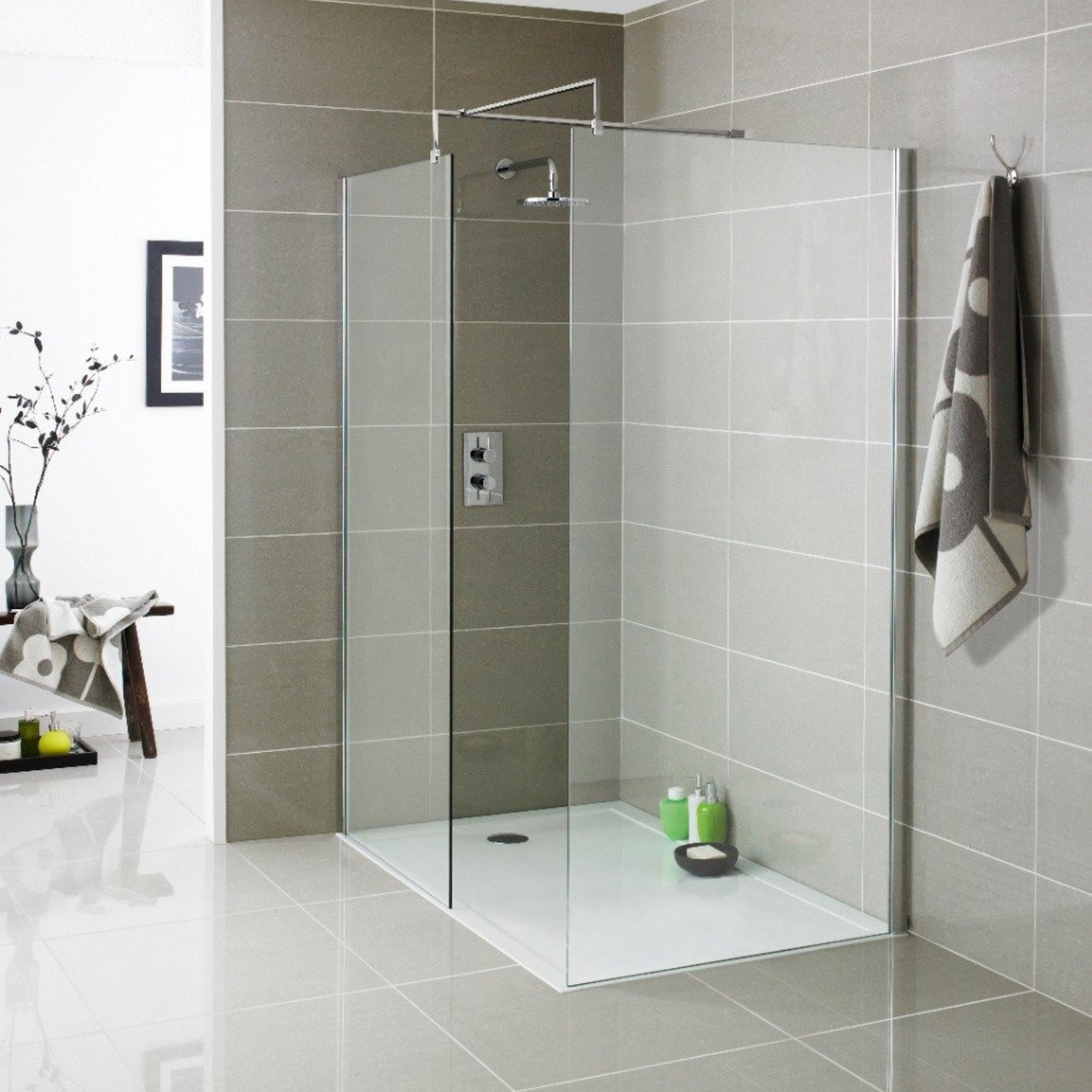 Modern bathroom with a glass shower enclosure, towel, and toiletries.