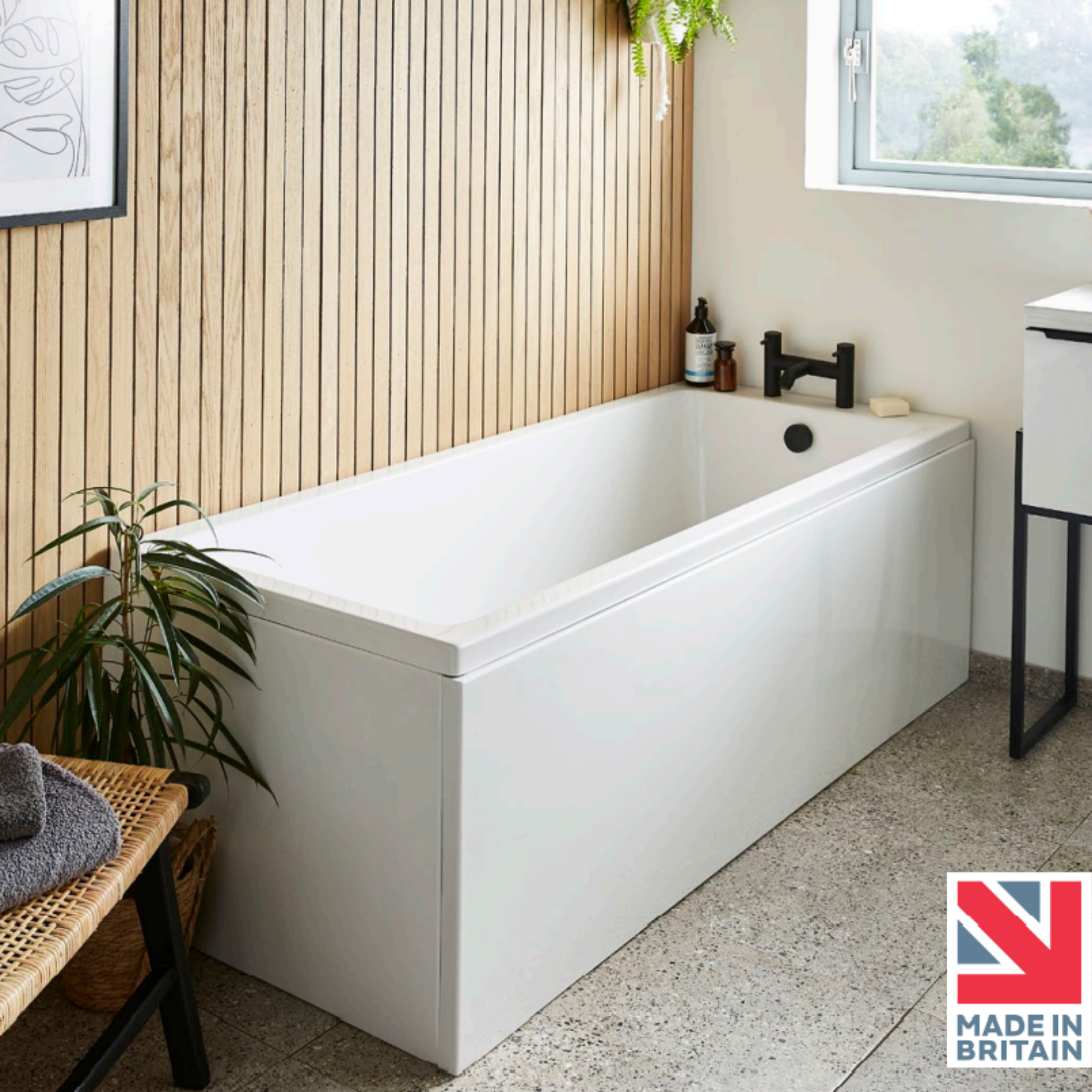 Modern bathroom with a white freestanding bathtub, wooden bench, and window.