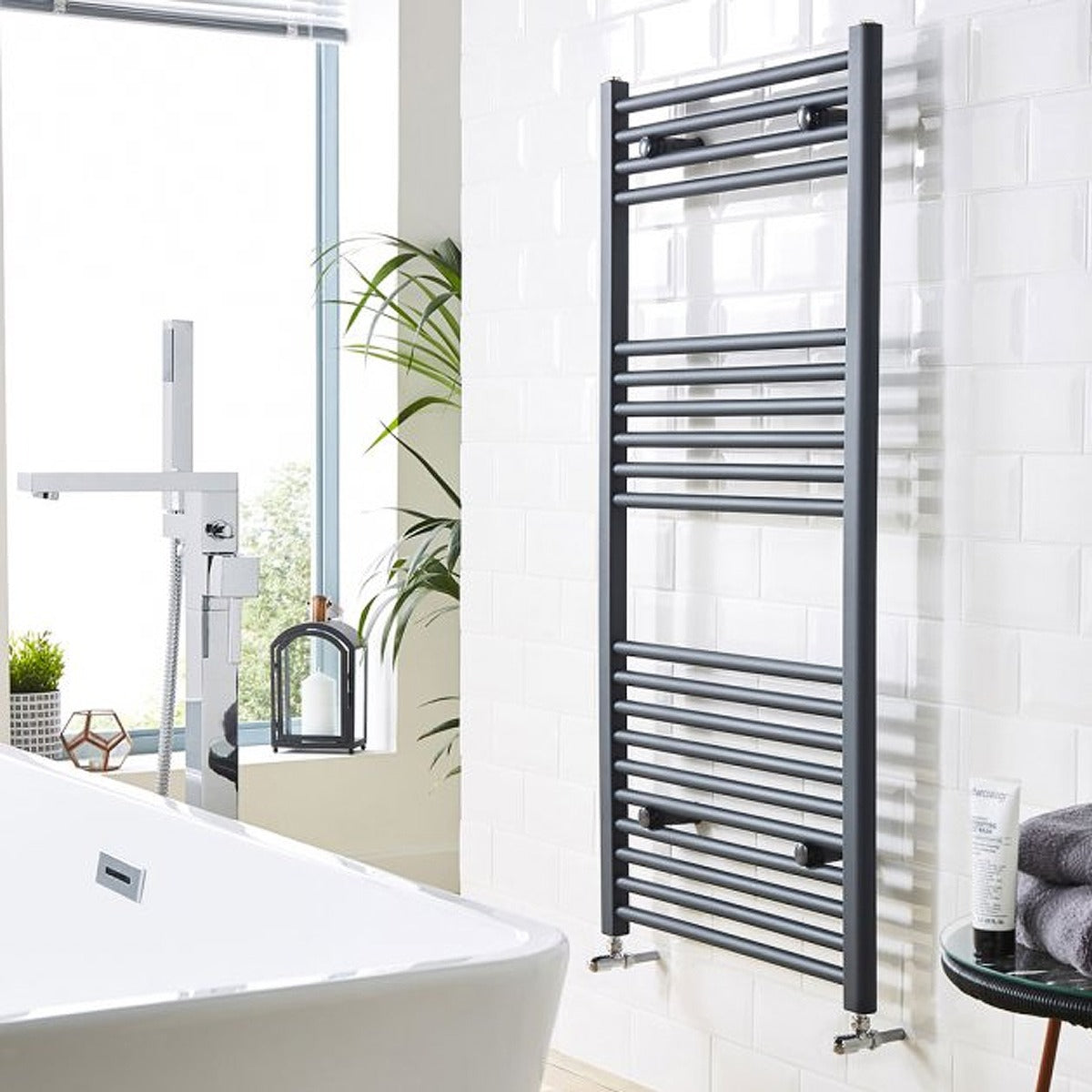 Towel radiator in a bathroom setting with a bathtub and window