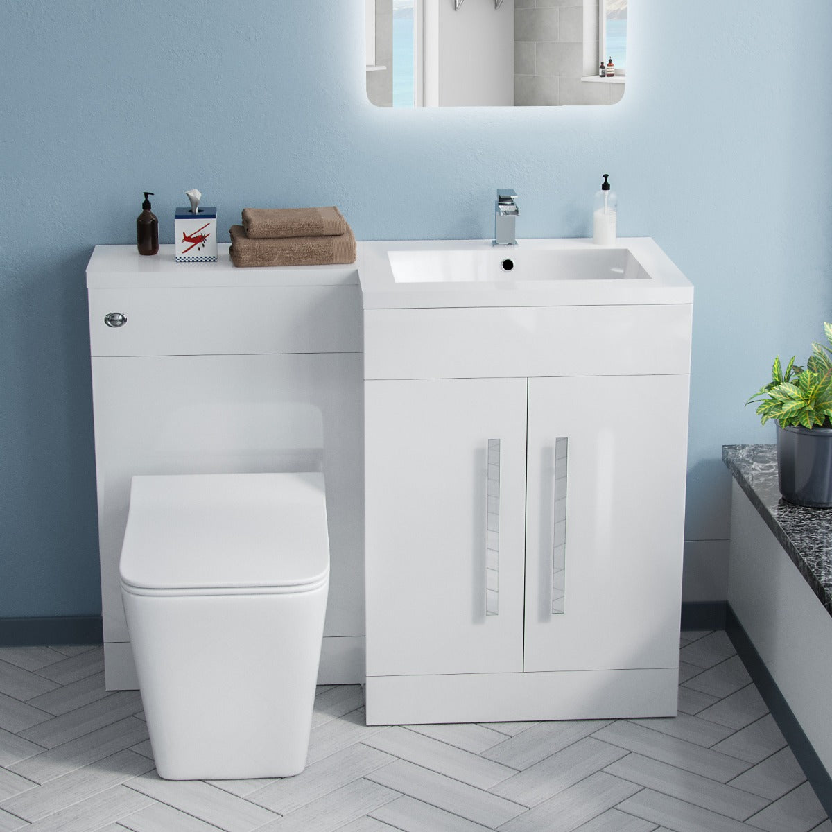 Bathroom setup with white vanity unit, toilet, and sink against a light blue wall.