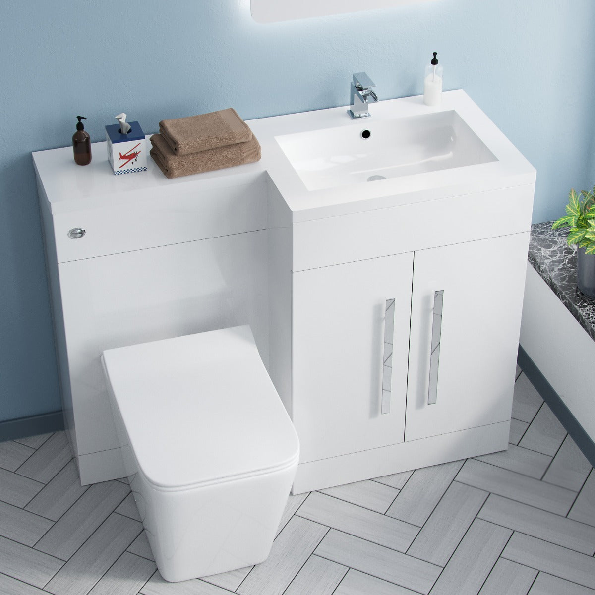 Bathroom setup with white vanity unit, sink, and toilet against a light blue wall.