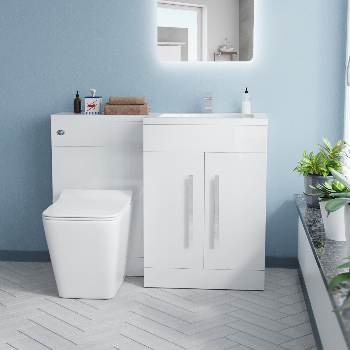 Bathroom setup with a white toilet and vanity unit against a light blue wall.