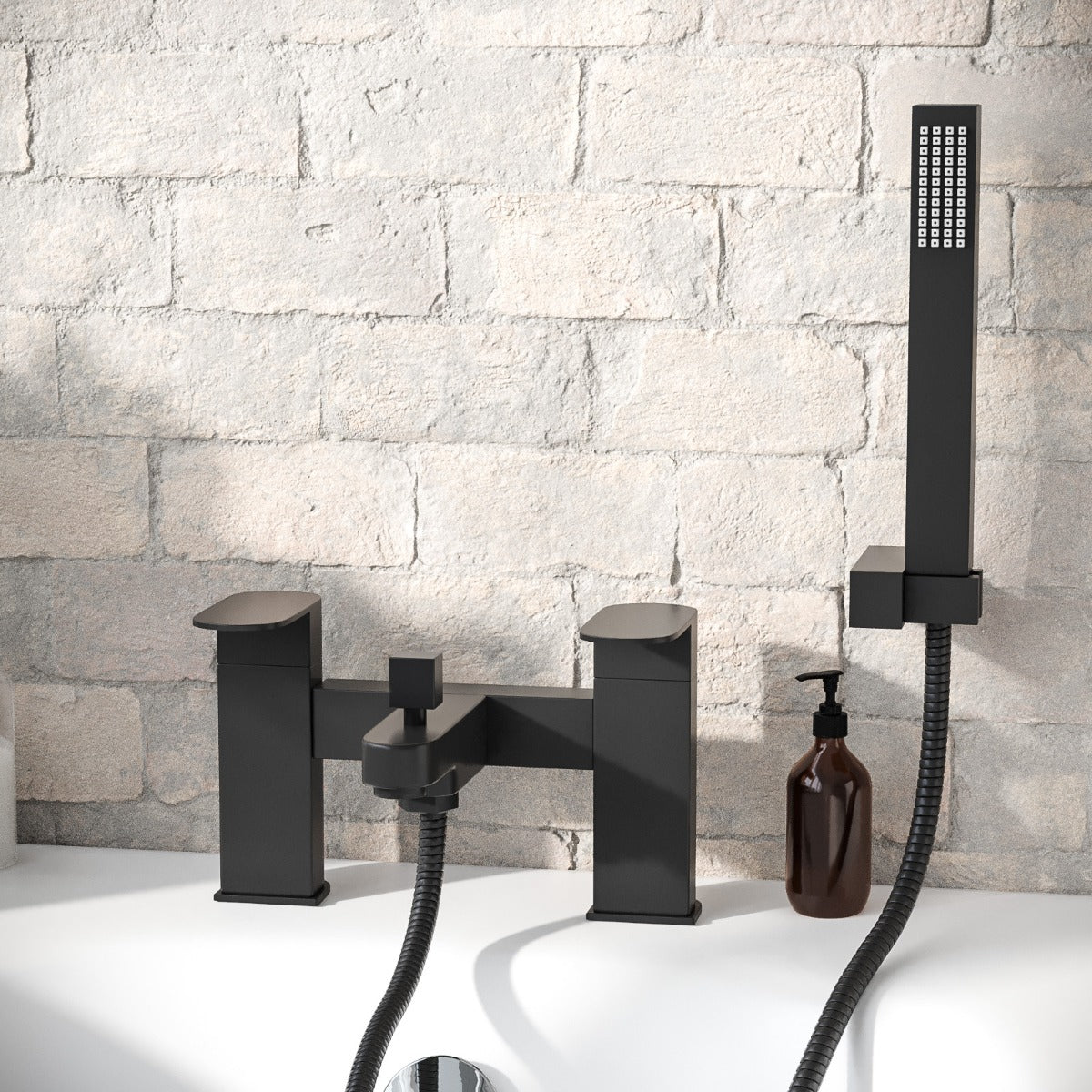 Black bathtub faucet and shower head set against a stone wall.