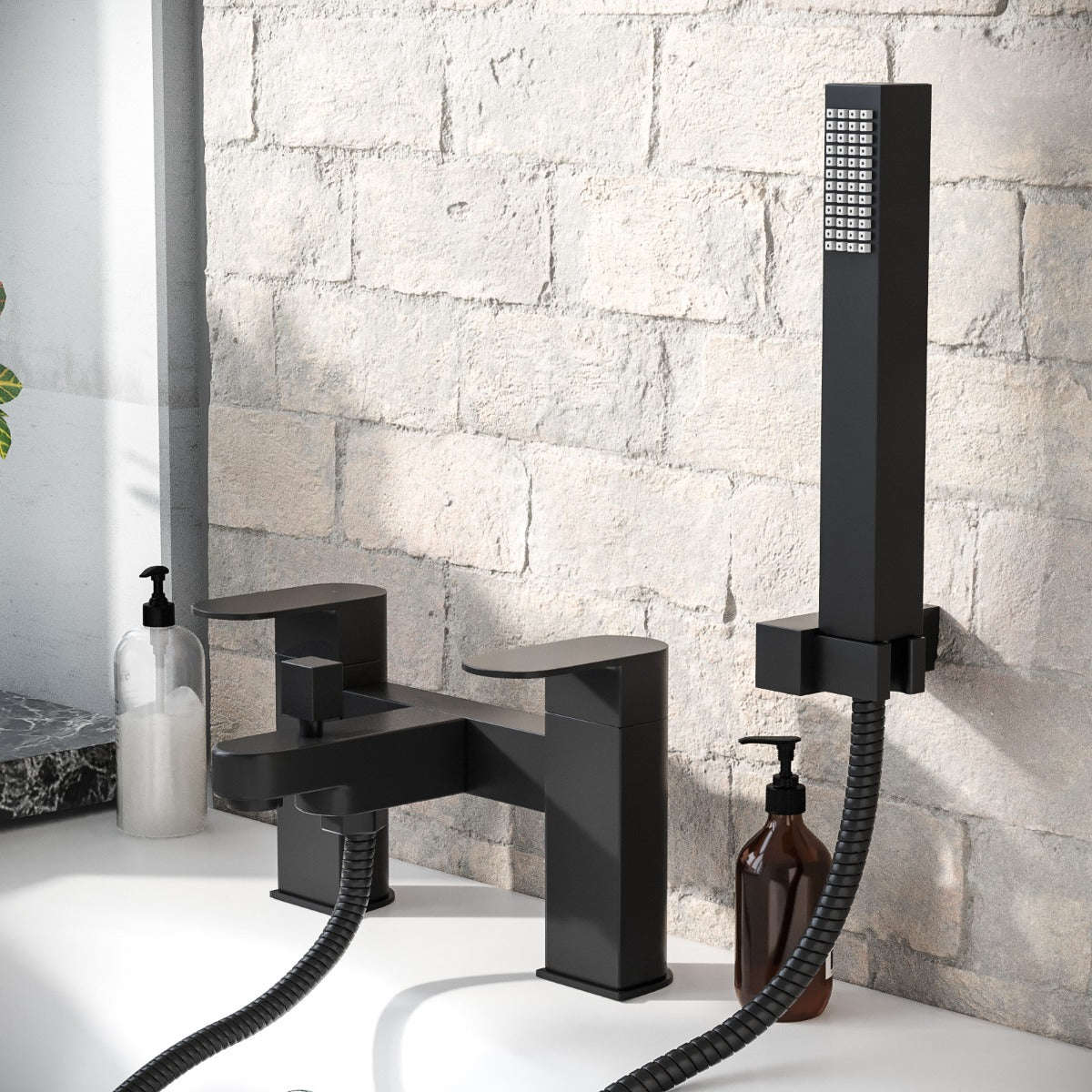 Black bathtub faucet with handheld shower head against a stone wall.